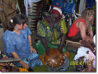 Fonziba-observes-woman-playing-a-clalbash-at-wedding